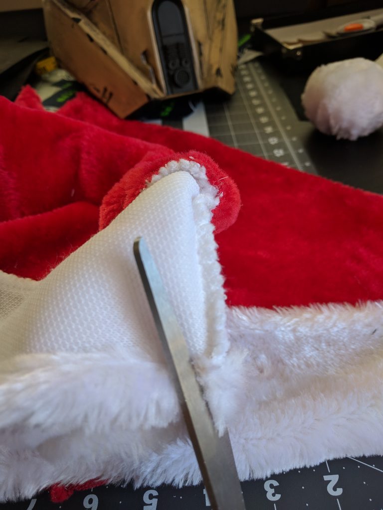 Cutting the seam off the Santa Hat.